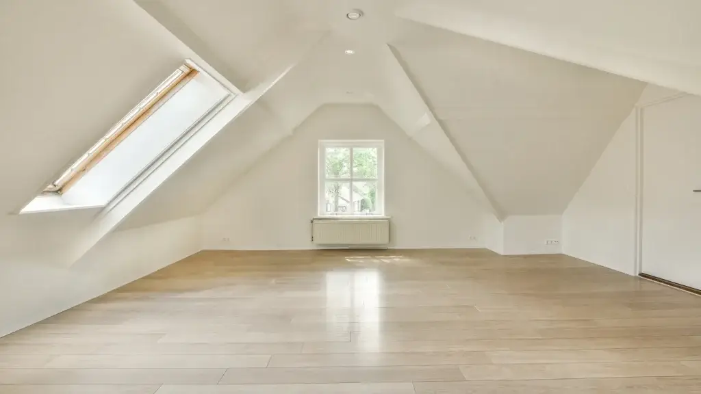 An image of a bright open converted loft space with a window and a skylight